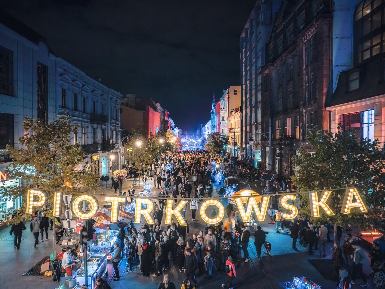 Ulica tętniąca życiem nocą z klimatycznym oświetleniem.