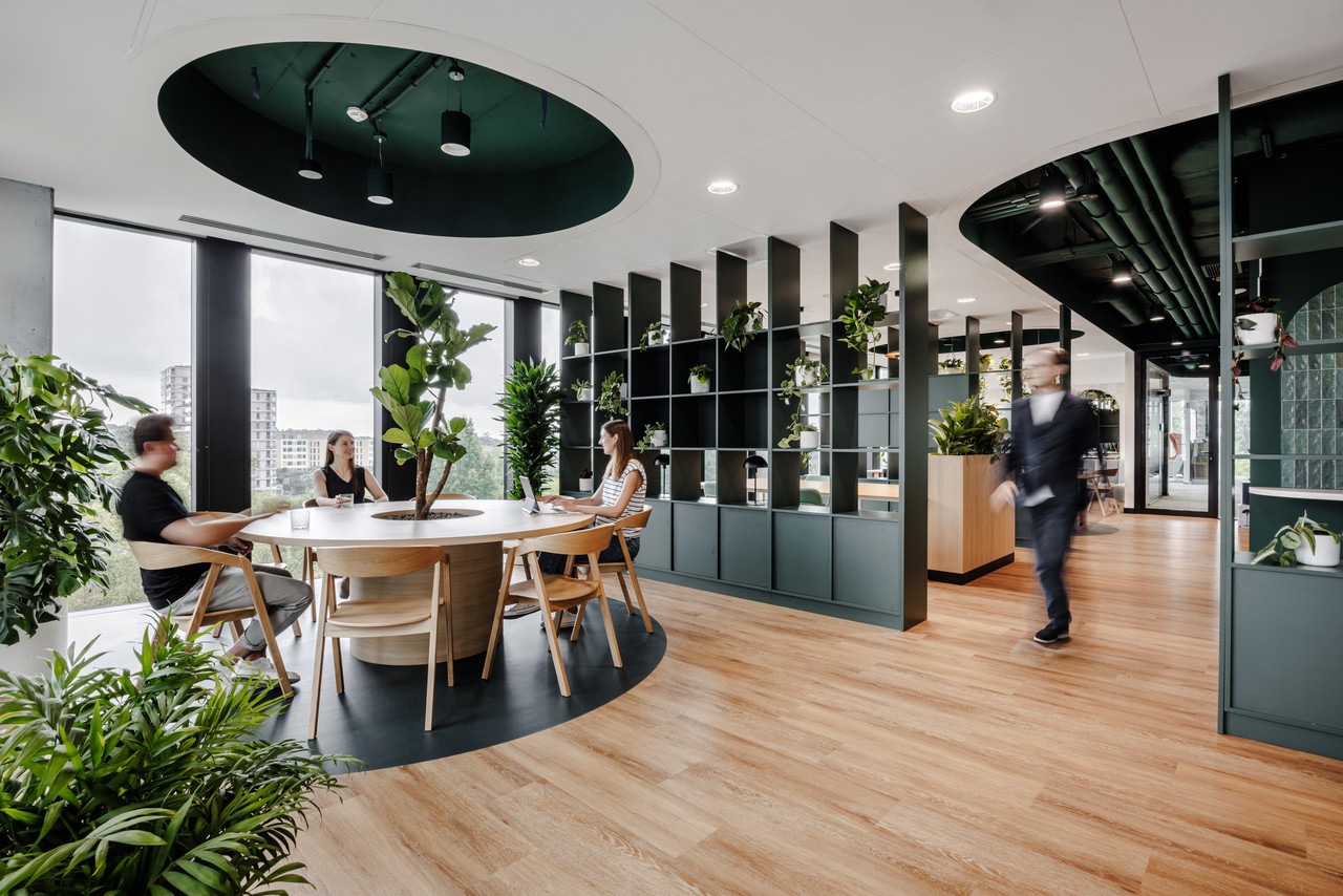 Biophilic design w biurze: rośliny, drewno, przestrzeń coworking.