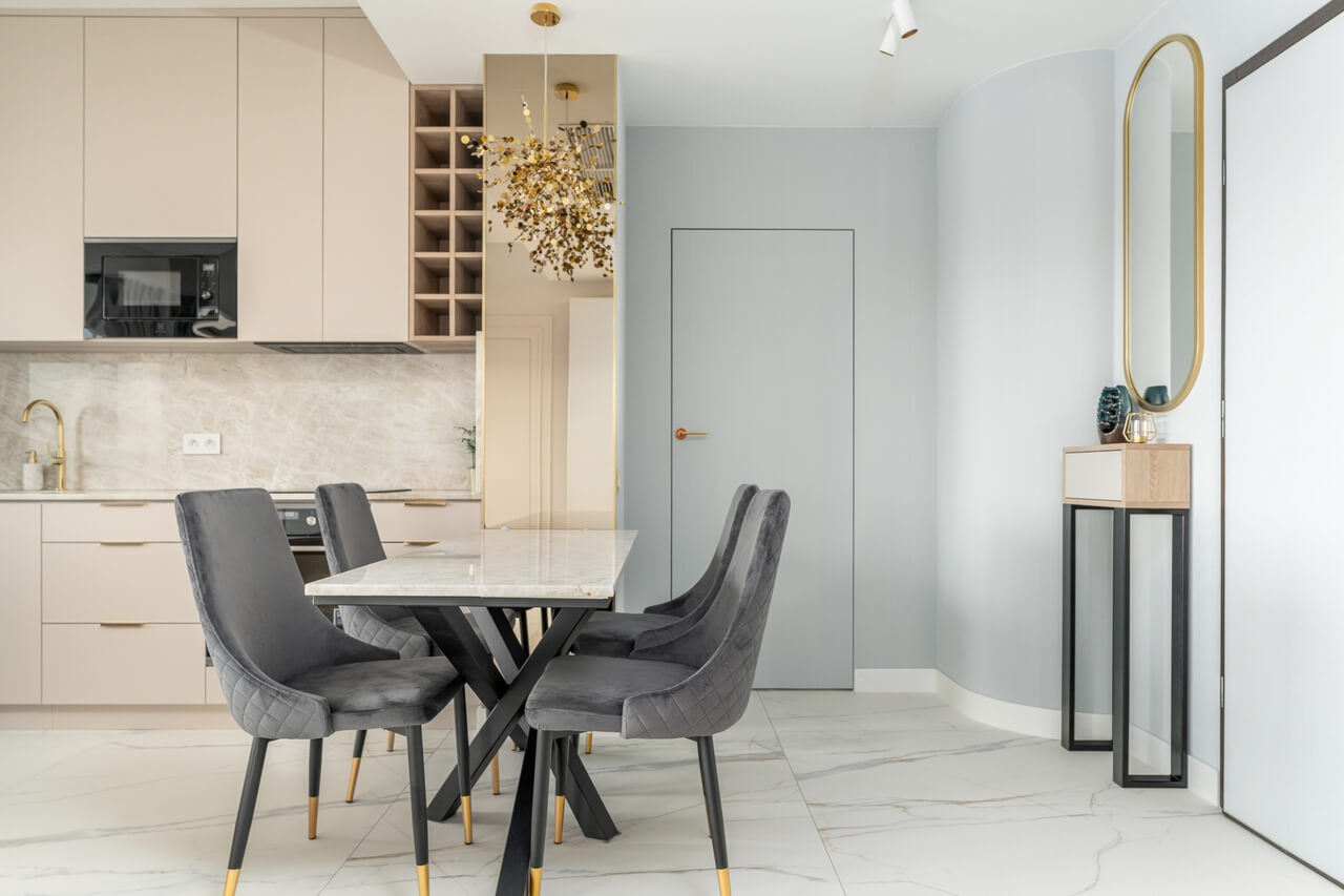 Nowoczesna kuchnia z eleganckim stołem i designerskimi krzesłami w szarym aksamicie