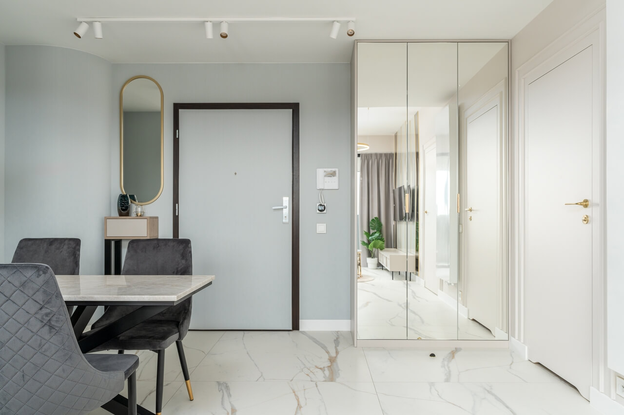 Przestronny przedpokój z lustrzaną szafą i minimalistyczną konsolą w stylu glamour