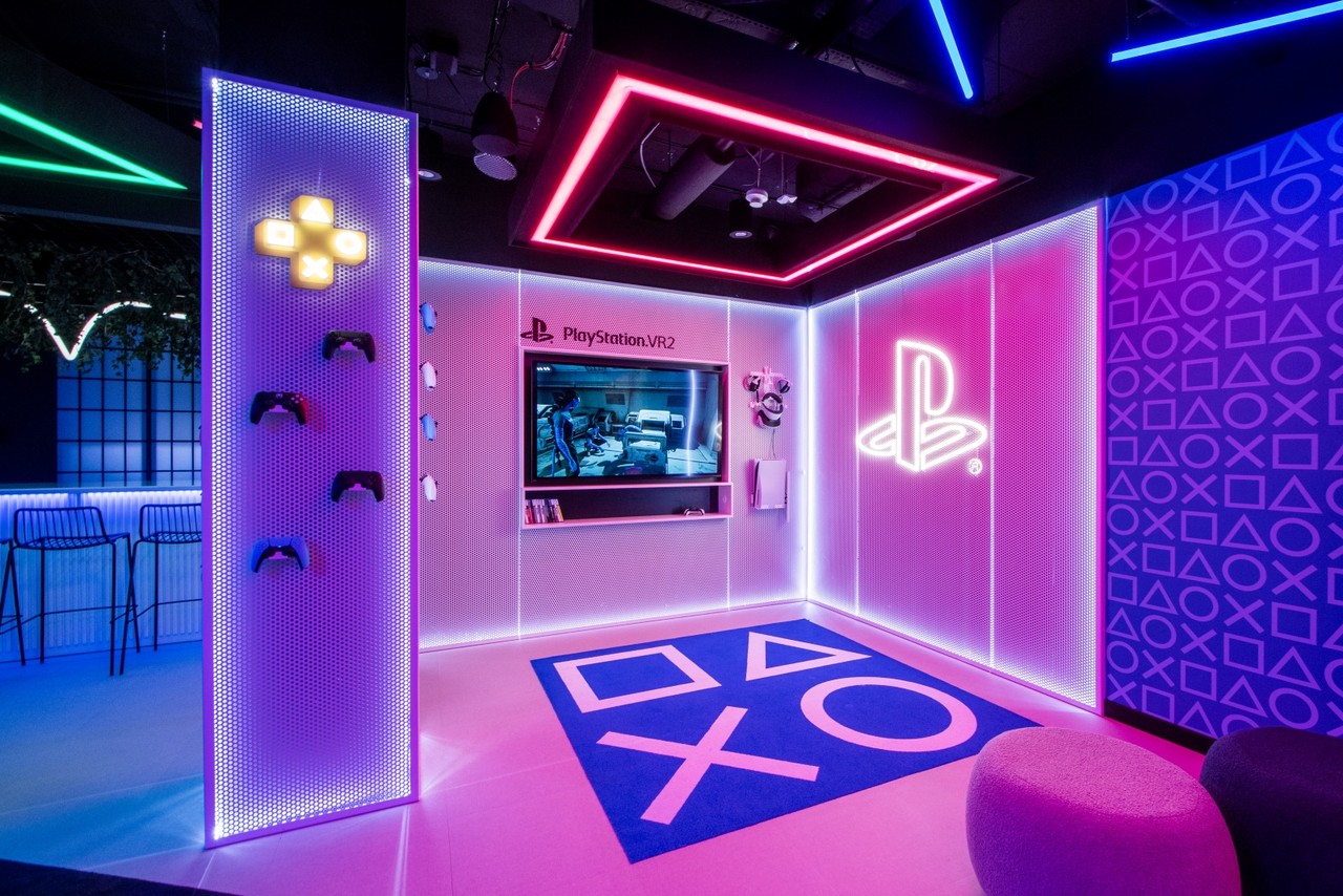 Neonowy salon gier z designerskimi elementami PlayStation.