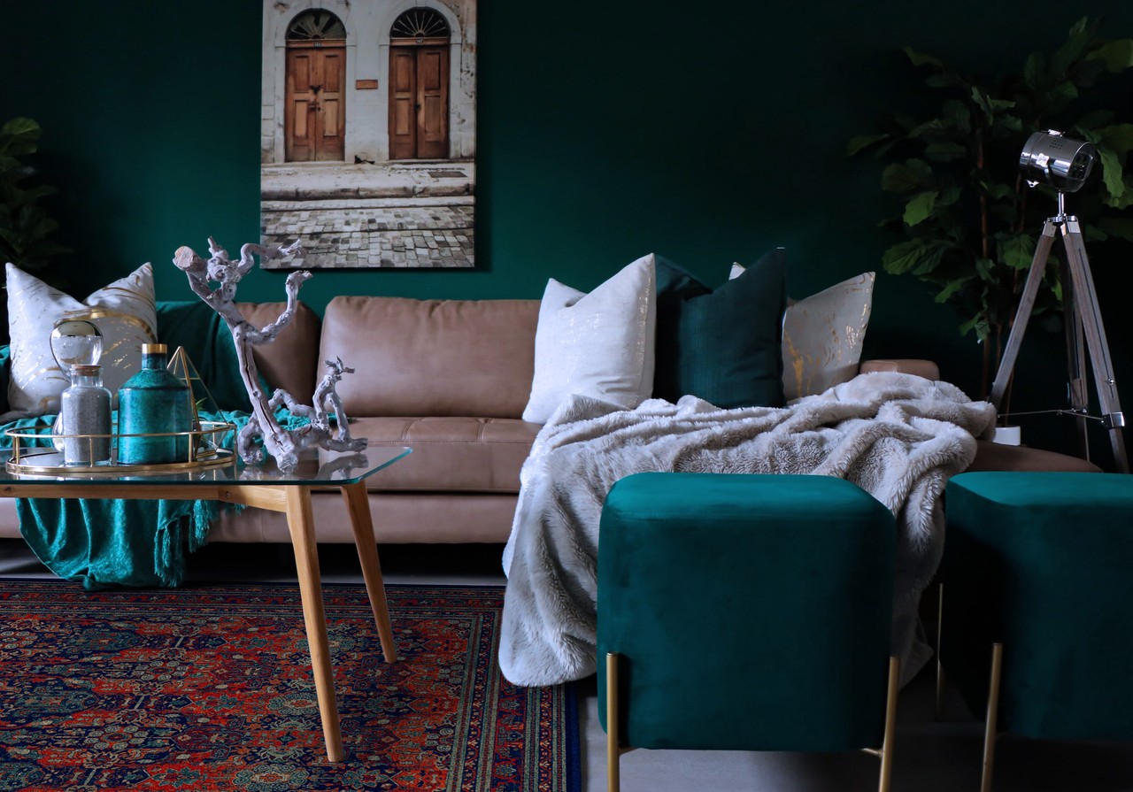 Stylowy salon z zielonymi akcentami i beżową sofą.