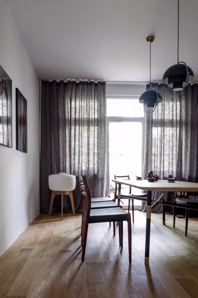 Jadalnia z designerskim stołem i nowoczesnymi lampami.