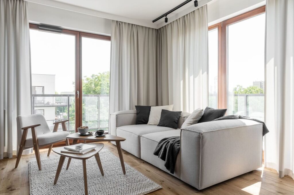 Szara sofa w salonie w 80-metrowym mieszkaniu w gdańskim Wrzeszczu