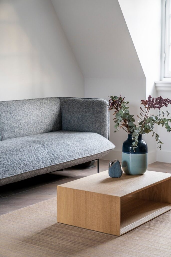 Szara sofa w minimalistycznym salonie