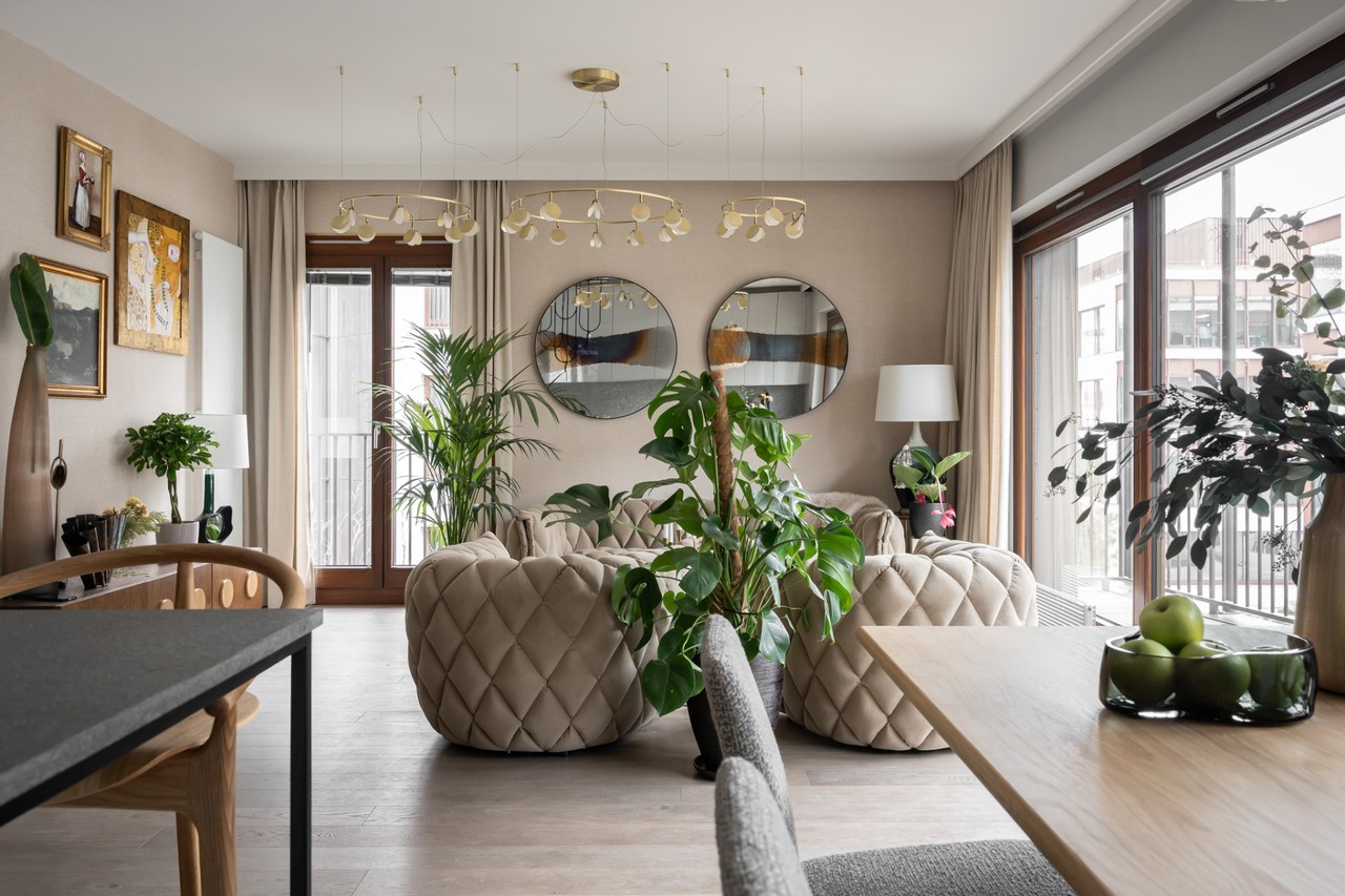 Przestronny salon z eleganckimi fotelami i dużymi lustrami.