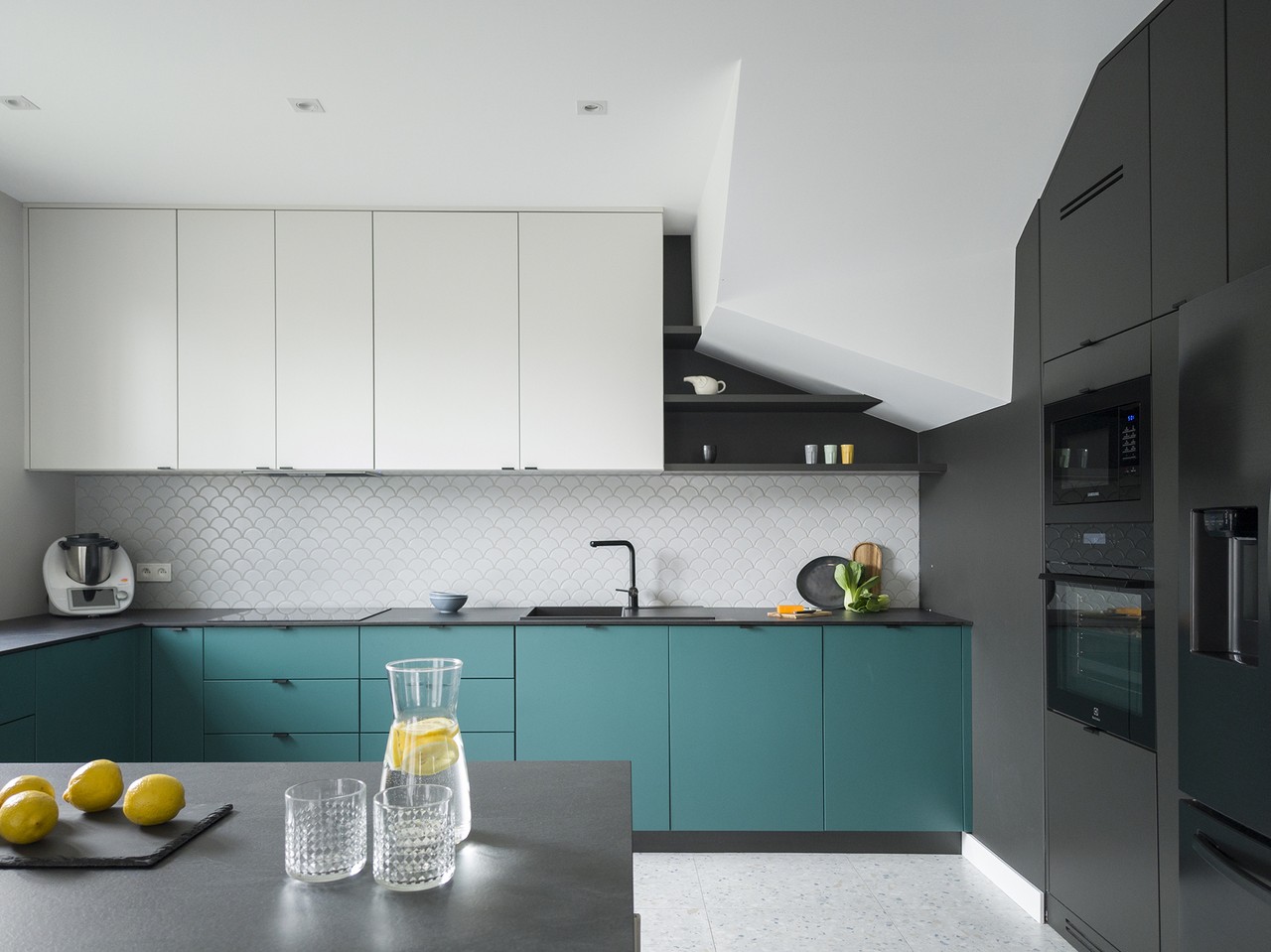 Modern kitchen with green cabinets and sleek details.