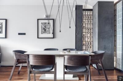 Nowoczesna jadalnia z designerskimi krzesłami i sztuką na ścianach.