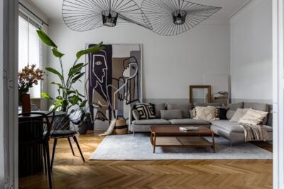 Nowoczesny salon z designerską sofą i abstrakcyjnym obrazem.