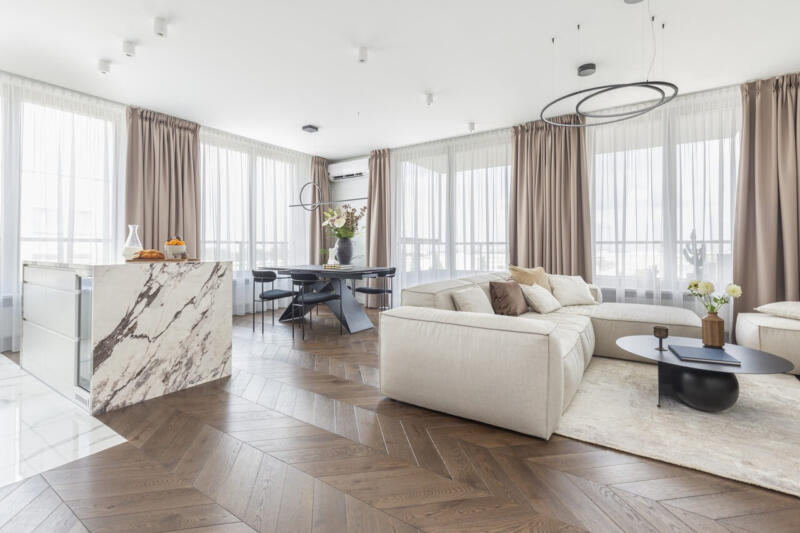 Nowoczesny salon z marmurową wyspą i eleganckimi dodatkami.