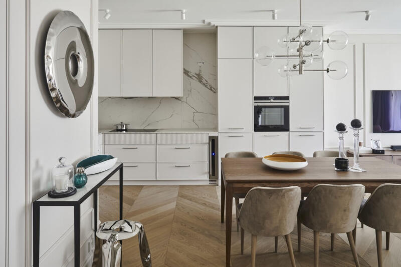 Nowoczesna kuchnia z drewnianą podłogą i designerskimi dodatkami.