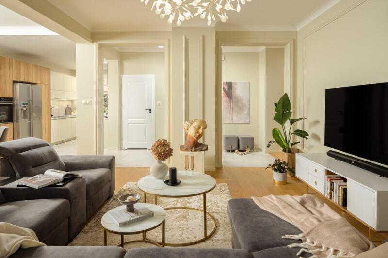 Przytulny salon z eleganckimi meblami i artystycznymi dodatkami.
