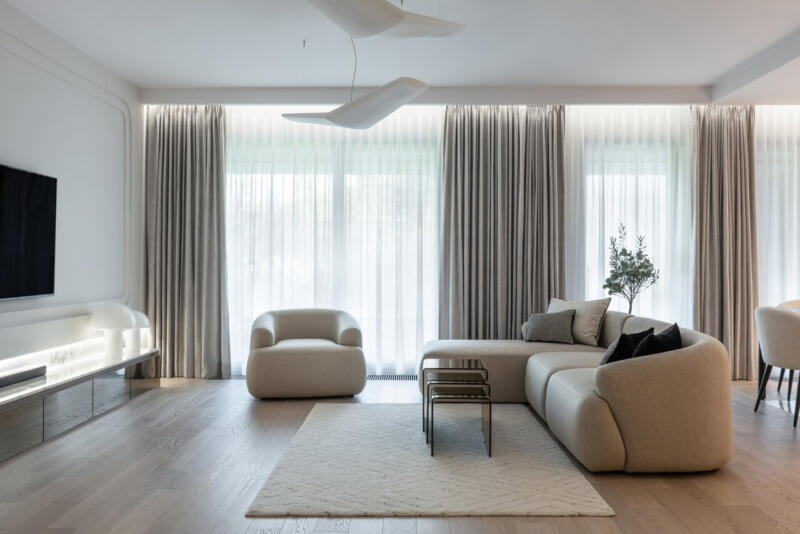 Elegancki salon w neutralnych barwach z nowoczesnymi meblami.