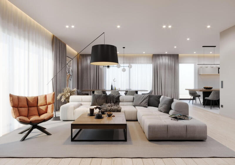Przestronny salon z eleganckim narożnikiem i designerskim fotelem.