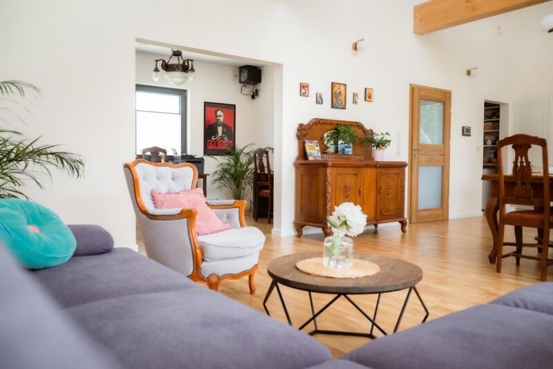 Przytulny salon w stylu retro z eleganckimi meblami i roślinami.