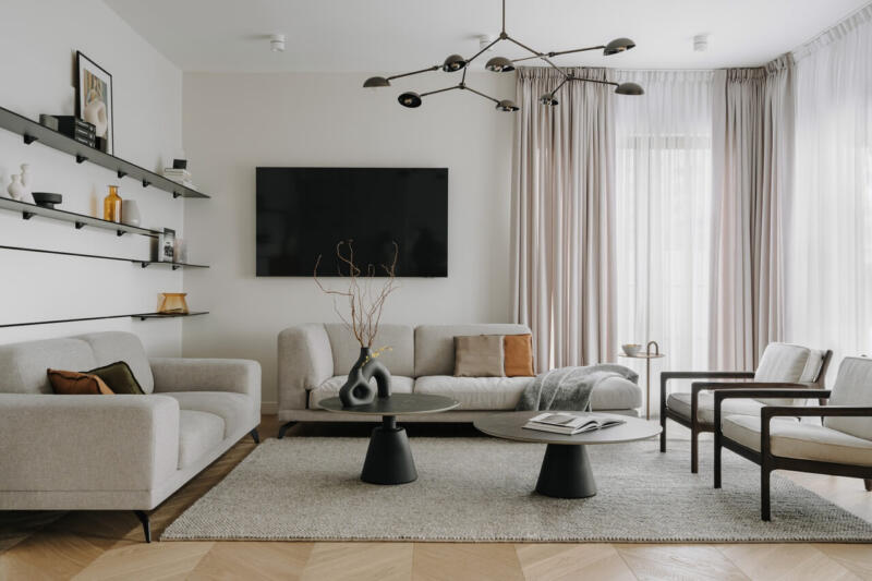 Nowoczesny salon z designerską sofą i minimalistycznymi półkami.