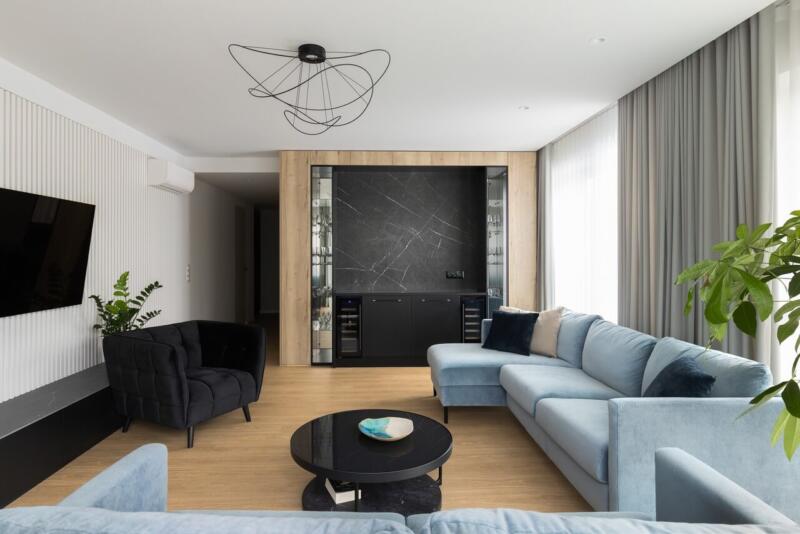 Nowoczesny salon z jasną sofą i designerskim oświetleniem.