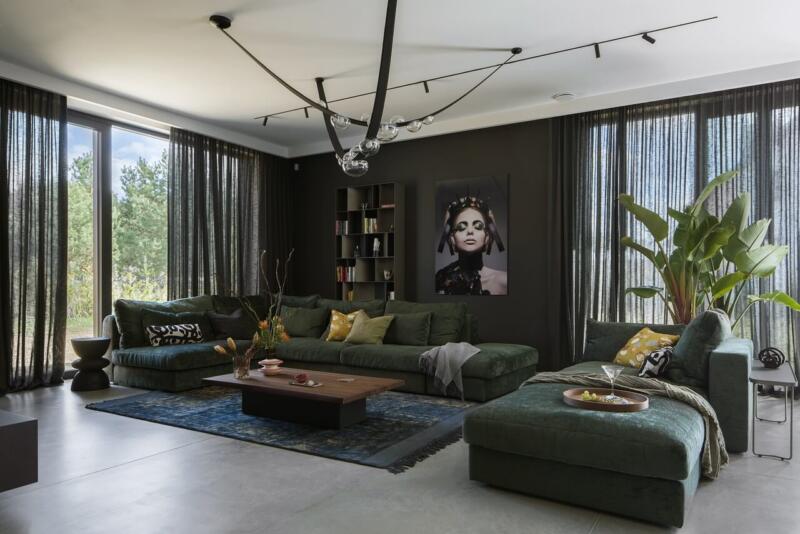 Elegancki salon w zieleni z nowoczesną sofą i obrazem.