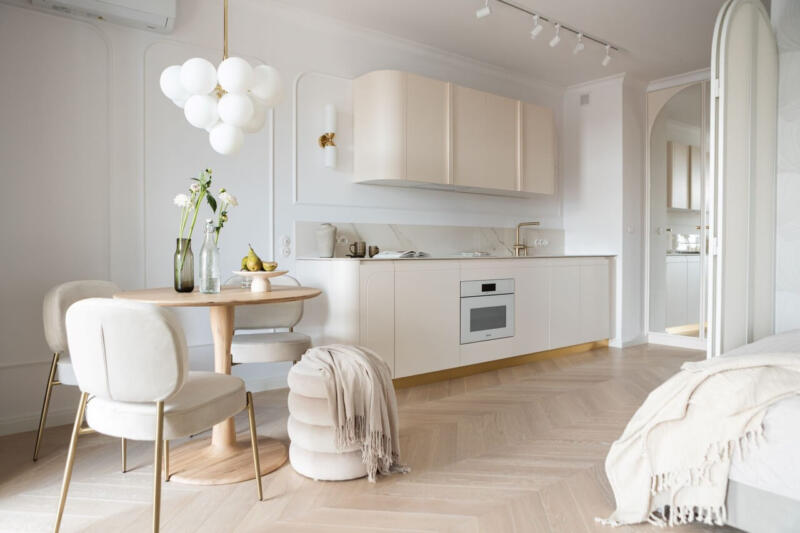 Nowoczesna kuchnia w neutralnych barwach, elegancki design i oświetlenie.