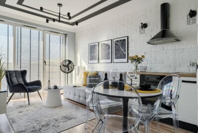 Nowoczesny salon z białą cegłą i designerskimi dodatkami.