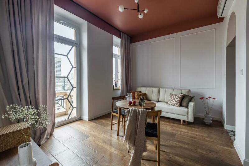 Przytulny salon z designerskim oświetleniem i drewnianą podłogą.