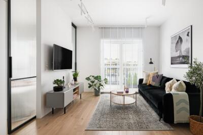 Nowoczesny salon z czarną sofą i stylowymi dodatkami.