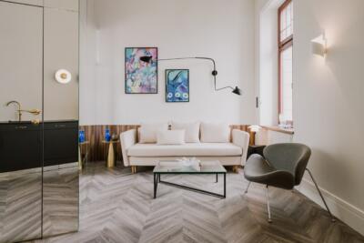 Nowoczesny salon z designerskimi lampami i sztuką na ścianie.