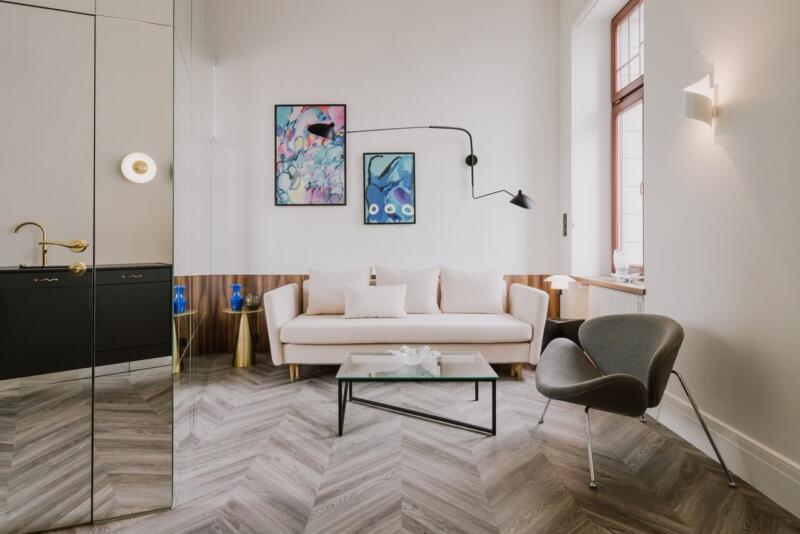 Nowoczesny salon z designerskimi lampami i sztuką na ścianie.