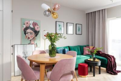 Przytulny salon z zieloną sofą i obrazem w kwiecistej oprawie. Jak miło!