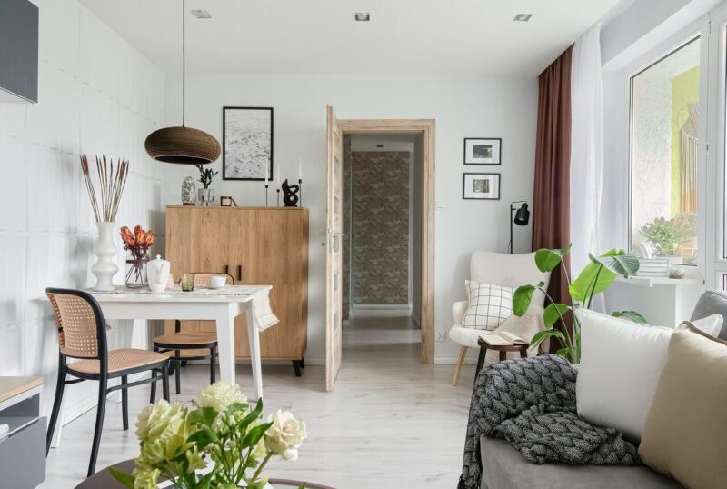 Przytulny salon z roślinami i jasnymi meblami. Nastrojowy design.