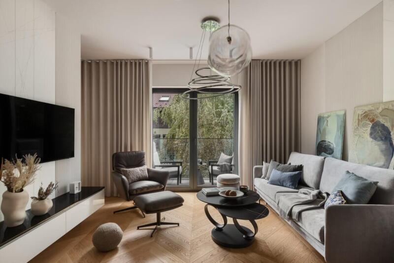 Przestronny salon z designerską sofą i stylowym fotelem. Idealnie, prawda?