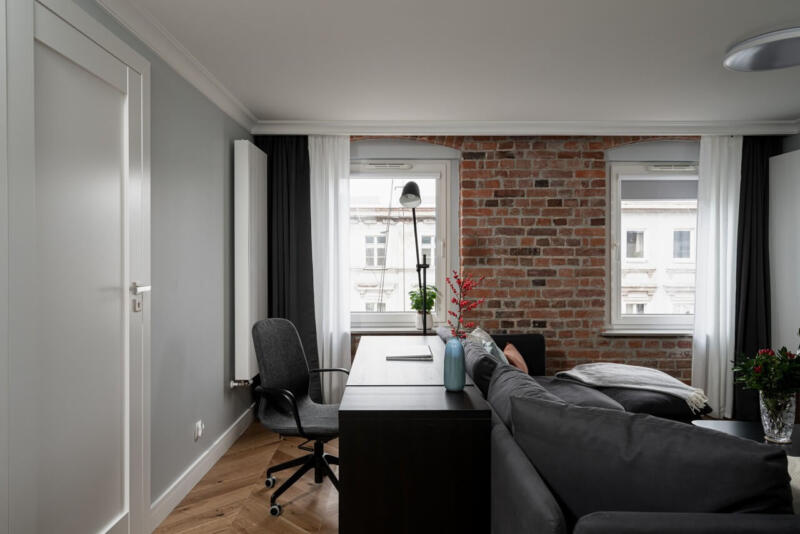 Nowoczesny loft z ceglaną ścianą i eleganckim biurkiem.