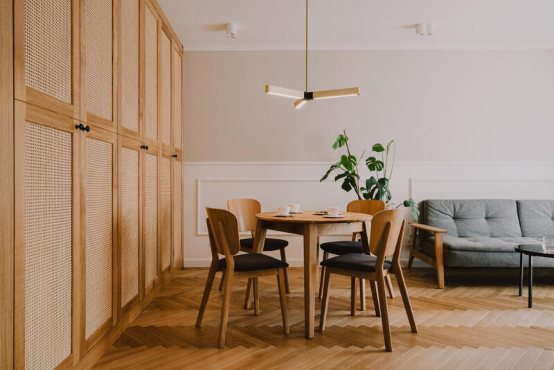 Salon w stylu skandynawskim, drewno i rośliny dodają ciepła wnętrzu.