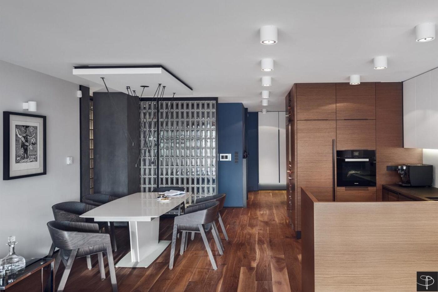 Nowoczesna jadalnia z designerskim stołem i eleganckimi krzesłami.