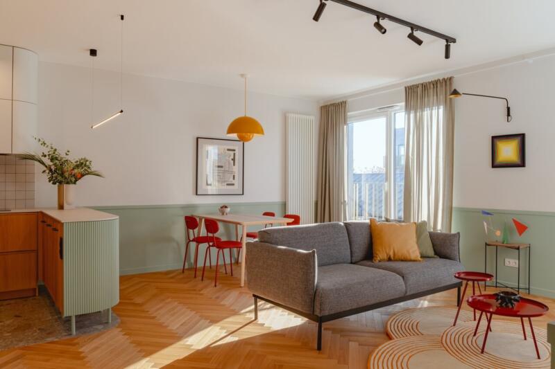Nowoczesny salon z designerskimi dodatkami i ciepłym oświetleniem.
