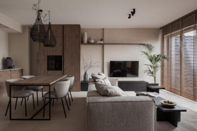 Salon w stylu minimalistycznym z drewnianymi akcentami i rośliną.