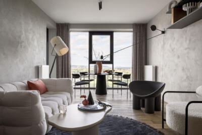Przestronny salon z designerskimi meblami i dużym oknem.