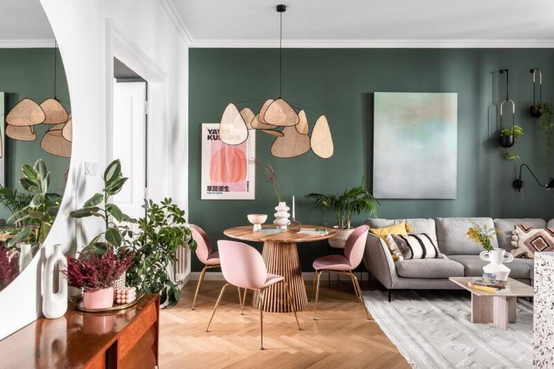 Stylowe wnętrze z zielonymi ścianami i designerskimi meblami.