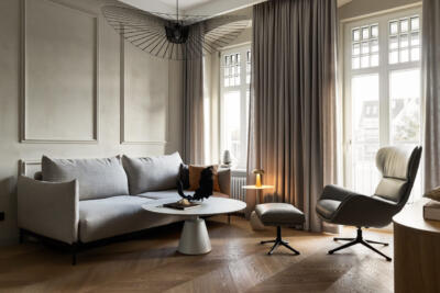 Elegancki salon z designerską lampą i sofą.