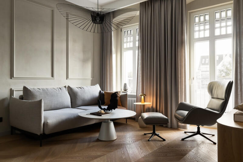 Elegancki salon z designerską lampą i sofą.