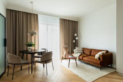 Nowoczesny salon z rdzawą sofą i eleganckim stołem.