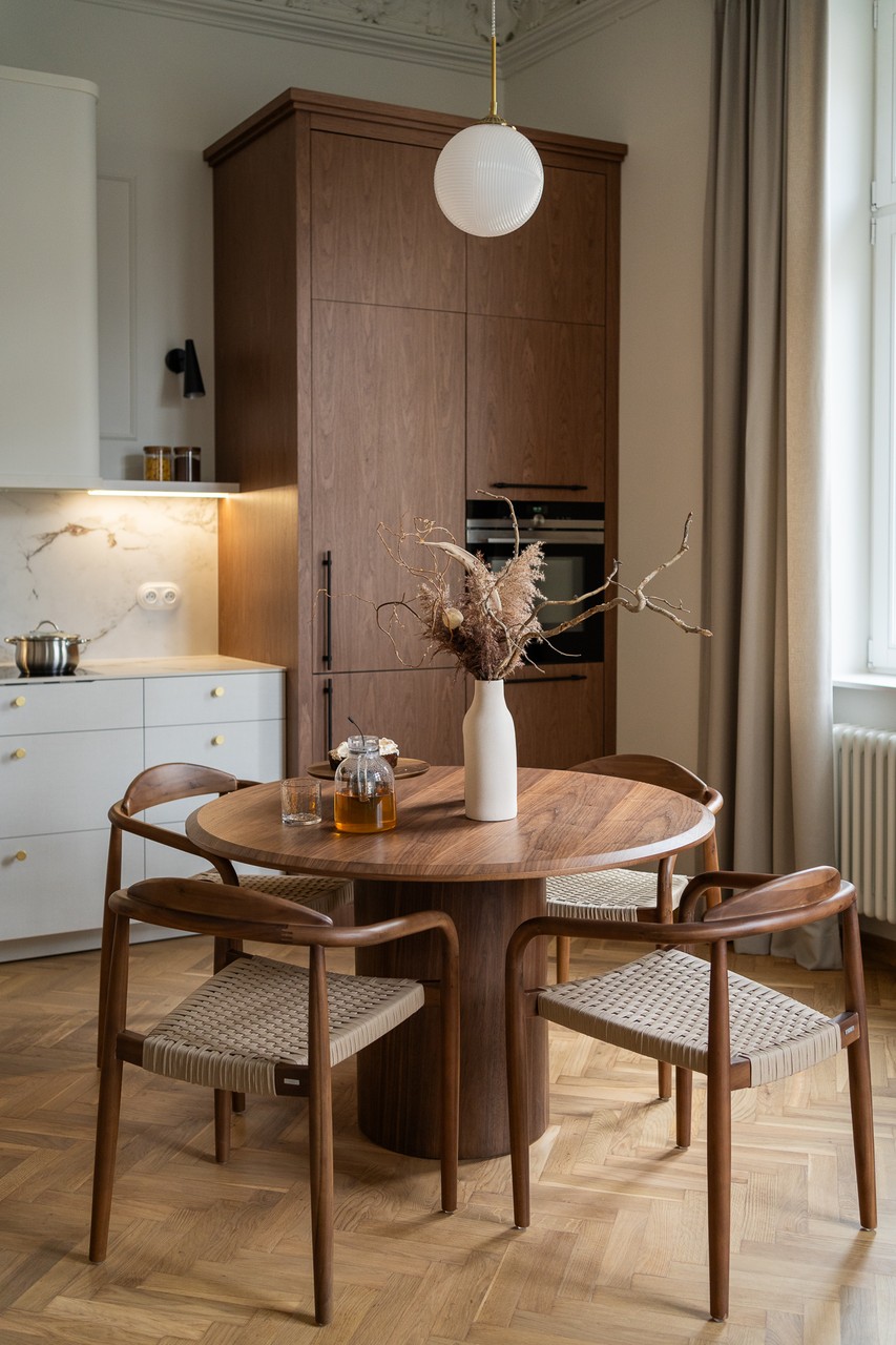 Przytulna jadalnia z drewnianym stołem i designerskimi krzesłami.
