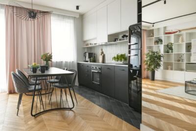 Nowoczesna kuchnia z designerskim stołem i stylowym oświetleniem.
