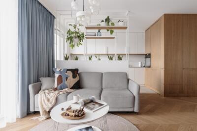 Elegancki salon z designerską kanapą i zielenią.