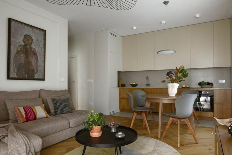 Nowoczesny salon z aneksem, eleganckie drewniane meble, przytulna sofa.