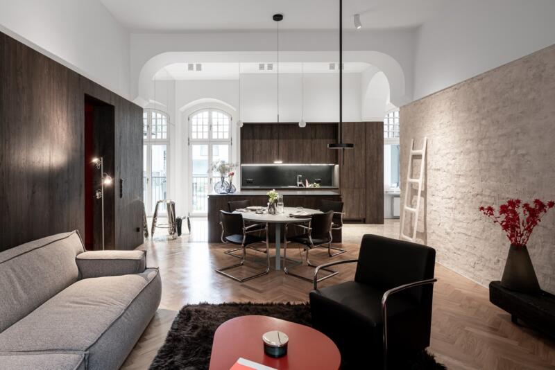 Jasny salon z nowoczesną kuchnią i eleganckimi detalami.