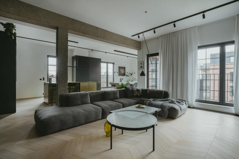 Nowoczesny salon z designerską sofą i industrialnymi akcentami.