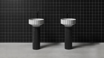 Minimalistyczne umywalki na tle eleganckiej, czarnej ściany z kafli.