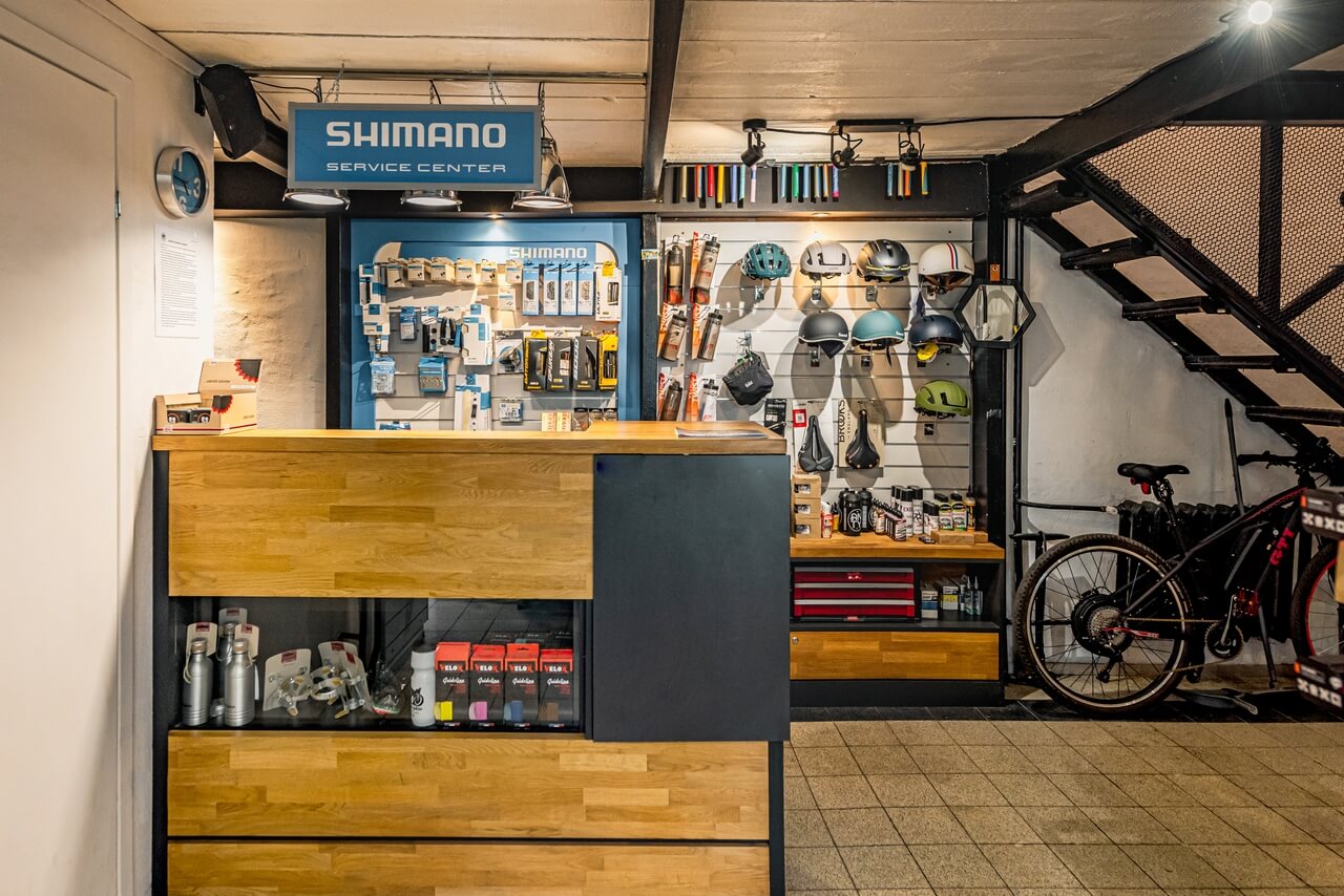 Serwis rowerowy z kaskami i akcesoriami w industrialnym wnętrzu.