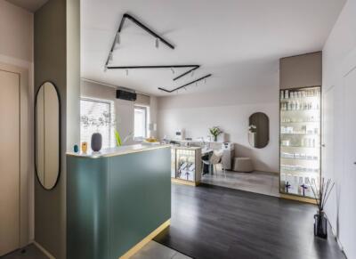Nowoczesny salon spa z eleganckim wystrojem i jasnym oświetleniem.